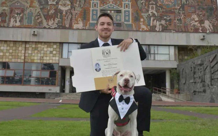 Perrito elegante acompaña a su dueño a recibir su título