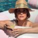 Jennifer Lopez posando en bikini blanco junto a una piscina en una lujosa villa de Los Ángeles para su Instagram.