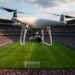 Operador de seguridad vigilando el espacio aéreo con tecnología de restricción para drones cerca de un estadio
