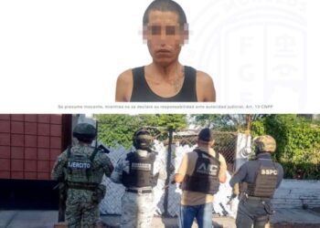 Elementos de la Agencia de Investigación Criminal de Morelos y de la Marina resguardando el exterior de una vivienda pintada durante un cateo en Tlaltizapán....