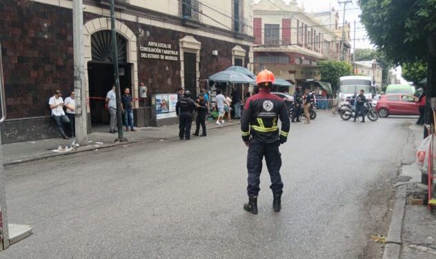Elementos de Protección Civil de Morelos y personal militar de la Defensa resguardando el perímetro exterior del edificio de la Junta Local de Conciliación y Arbitraje en Cuernavaca durante las labores de evacuación y revisión con binomios caninos.
