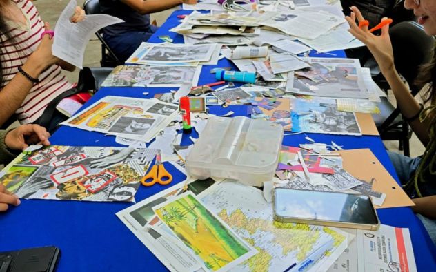 Personas de distintas edades sentadas en mesas al aire libre en el Parque Melchor Ocampo de Cuernavaca, recortando revistas y pegando elementos naturales en cartulinas para crear collages.
