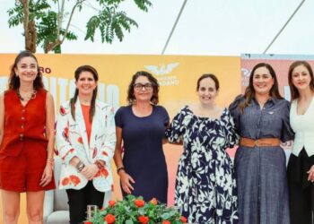 Fotografía del presídium del foro "Del Territorio al Poder" en Morelos, mostrando a Jessica Ortega, Alejandra Barrales y Anayeli Muñoz hablando frente a un auditorio lleno de mujeres con pancartas y pañuelos violetas.