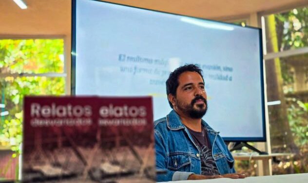 El escritor morelense Jorge Antonio Mora conversando con el público asistente y mostrando su libro dentro de la biblioteca pública del Parque Melchor Ocampo en Cuernavaca.